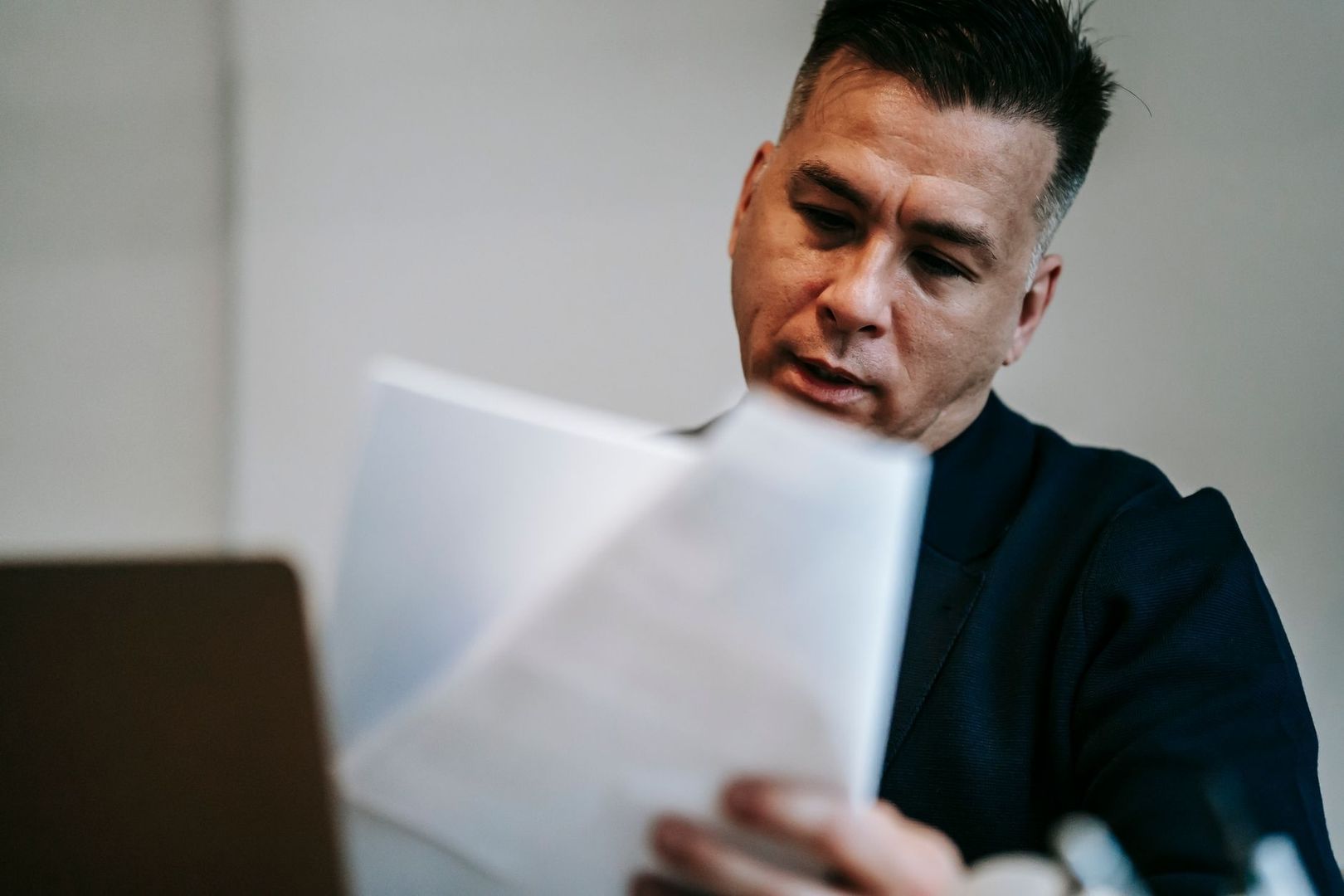 Homme examinant des documents devant un ordinateur