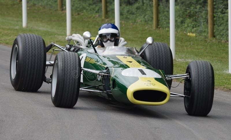 Ancienne monoplace Lotus verte et jaune roulant sur une piste