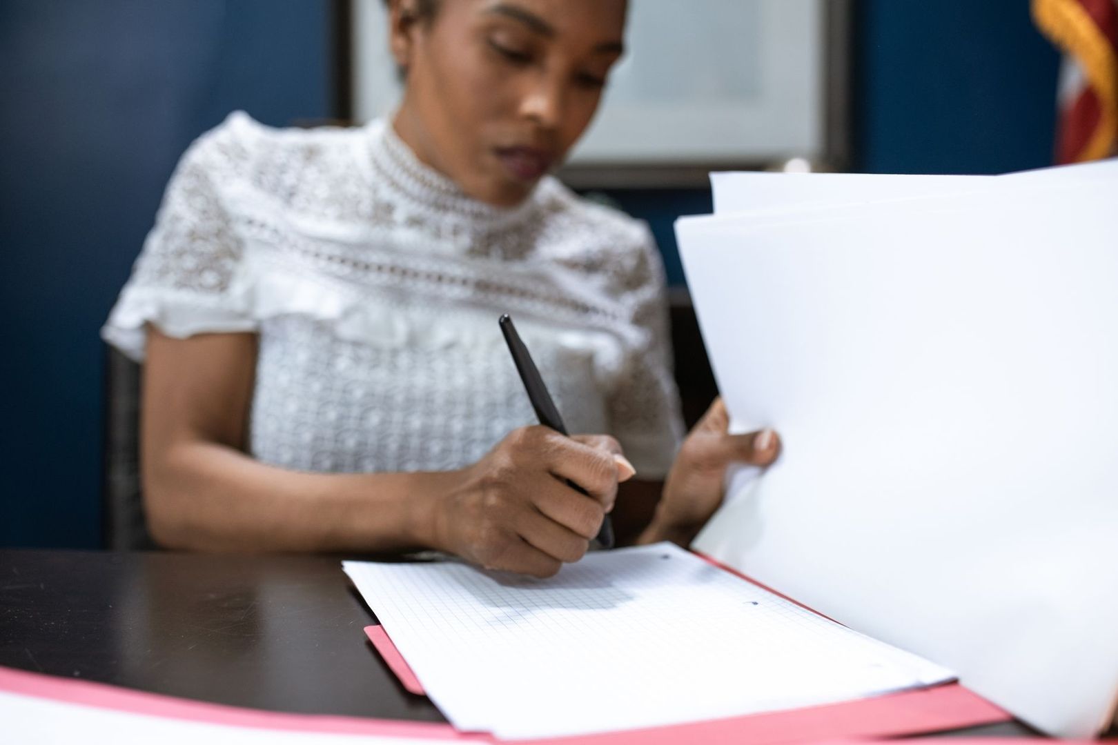 Personne consultant des documents et écrivant sur un formulaire